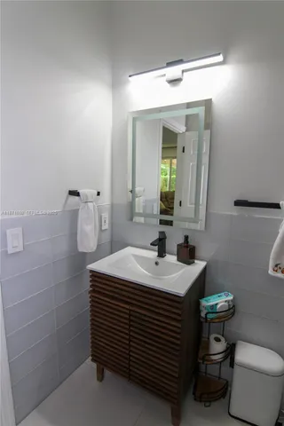 a bathroom with a sink a toilet and mirror