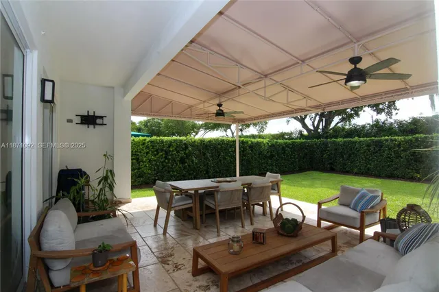 a view of a patio with couches chairs potted plants and a big yard