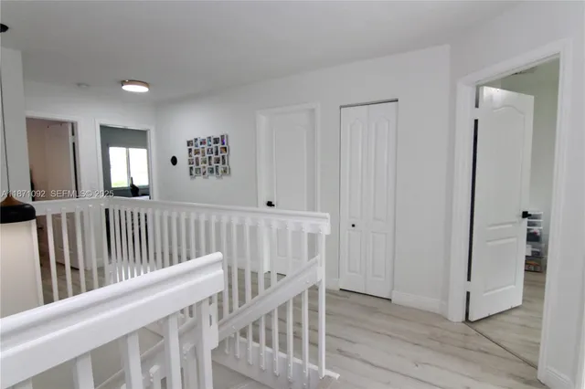 a view of hallway with stairs and wooden floor