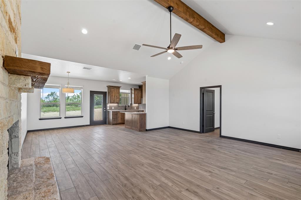 5470 Compass Way Bluff Dale, TX 76433 - Photo 6 of 26 a view of a big room with wooden floor a ceiling fan and windows
