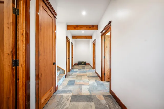 a view of a hallway with wooden floor and windows
