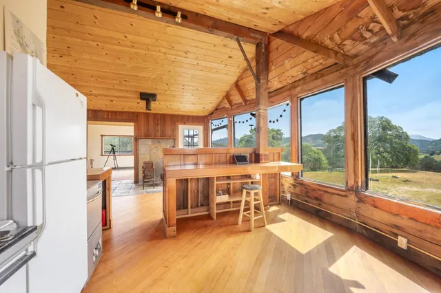 a room with wooden floor table and chairs