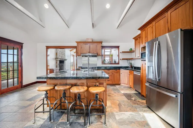 a kitchen with stainless steel appliances granite countertop a refrigerator and a stove top oven