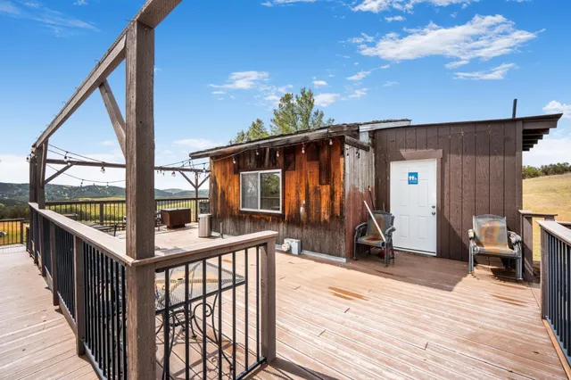 a view of a house with wooden deck and furniture
