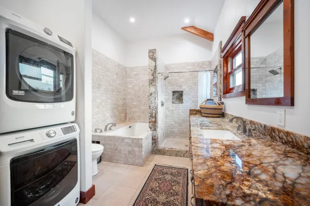a spacious bathroom with a tub sink and mirror