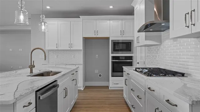 a kitchen with stainless steel appliances granite countertop a sink stove and cabinets