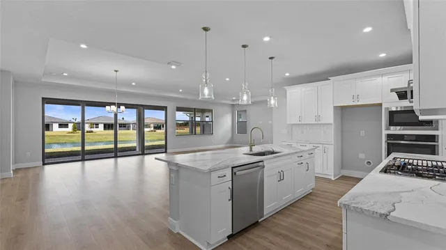 a kitchen with stainless steel appliances granite countertop a sink and cabinets