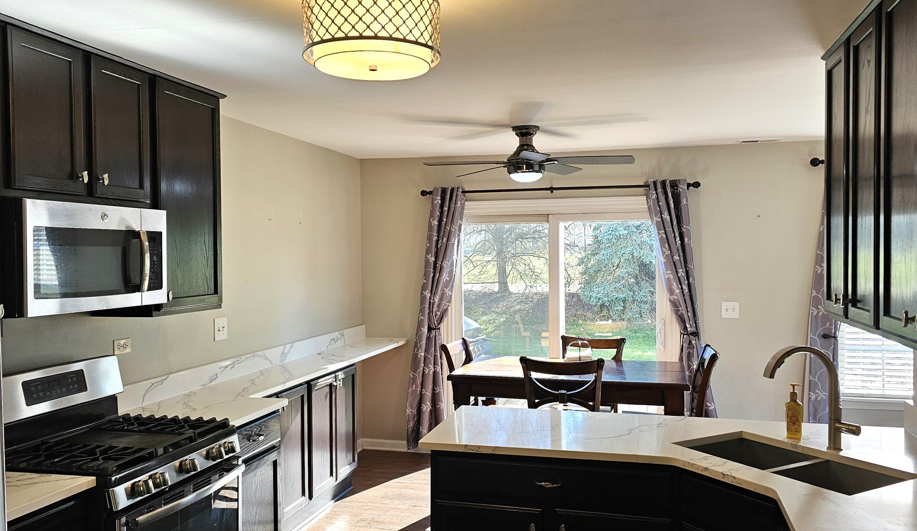 16047 Tiger Drive Lockport, IL 60441 - Photo 6 of 24 a kitchen with a stove a sink and a microwave