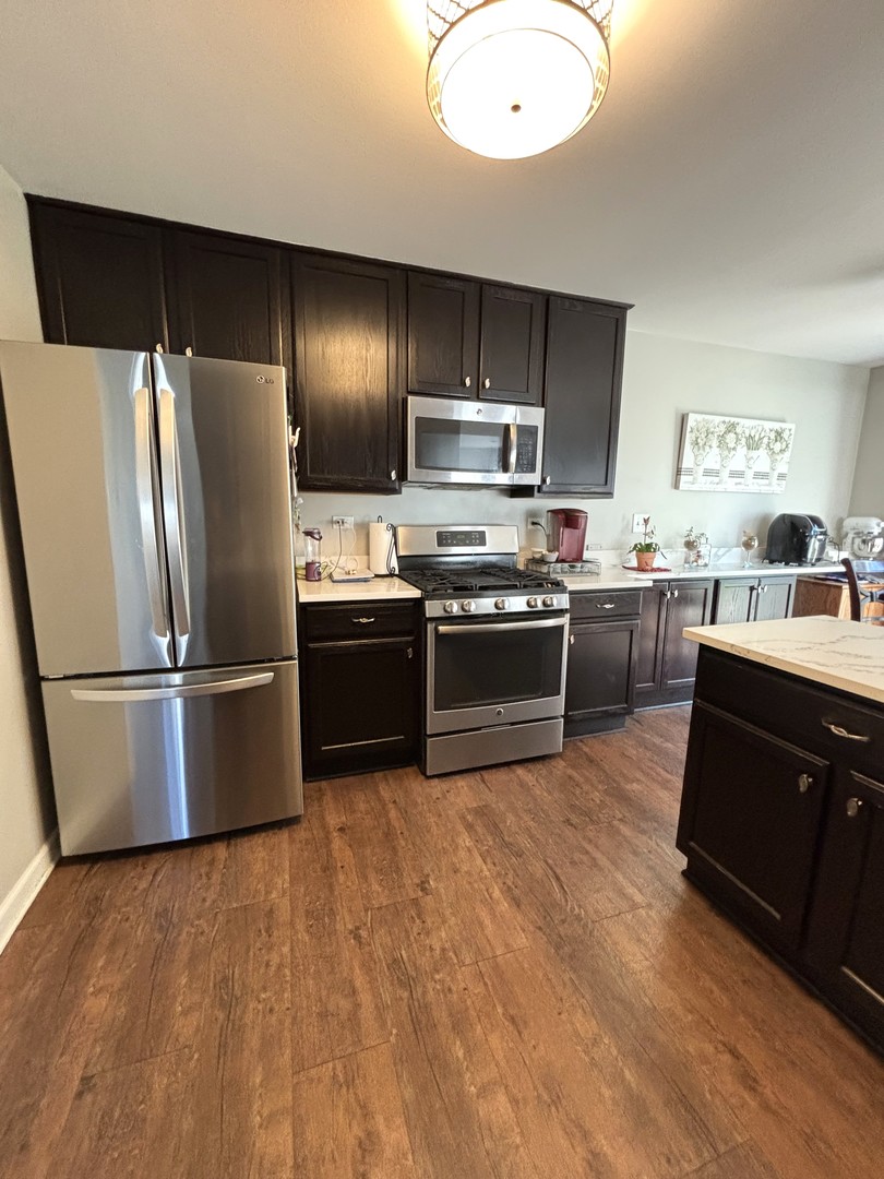16047 Tiger Drive Lockport, IL 60441 - Photo 9 of 24 a kitchen with stainless steel appliances granite countertop a refrigerator a sink a stove a microwave and island