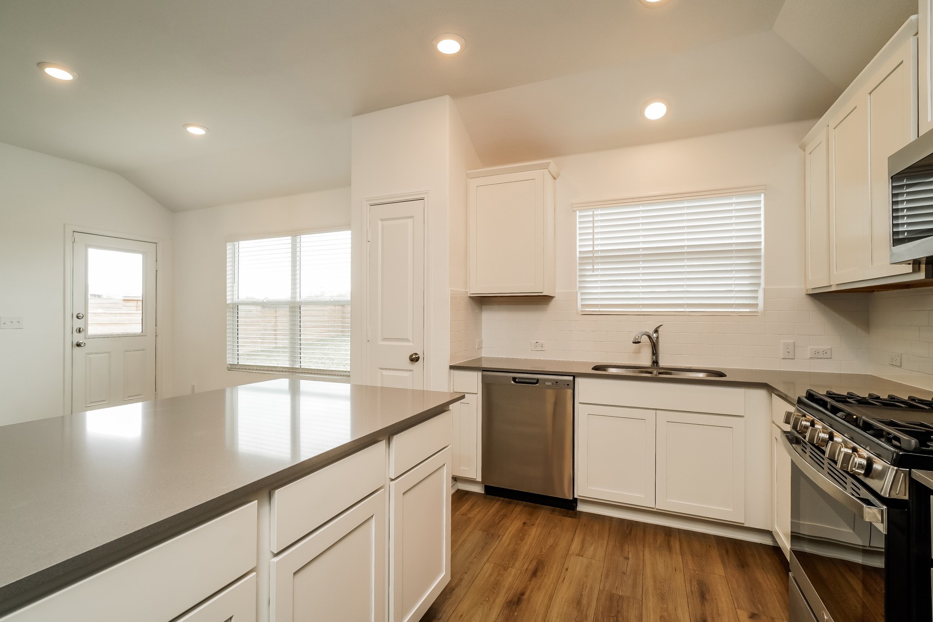 341 Madrid Kyle, TX 78640 - Photo 10 of 27 Modern kitchen with sleek counters and bright lighting.