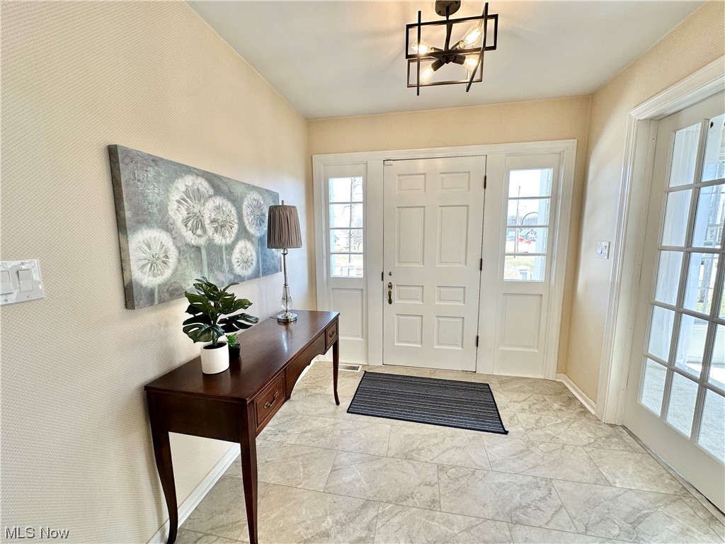 6130 Renninger Road New Franklin, OH 44319 - Photo 3 of 30 Foyer entrance with a chandelier and new LVT tile floors