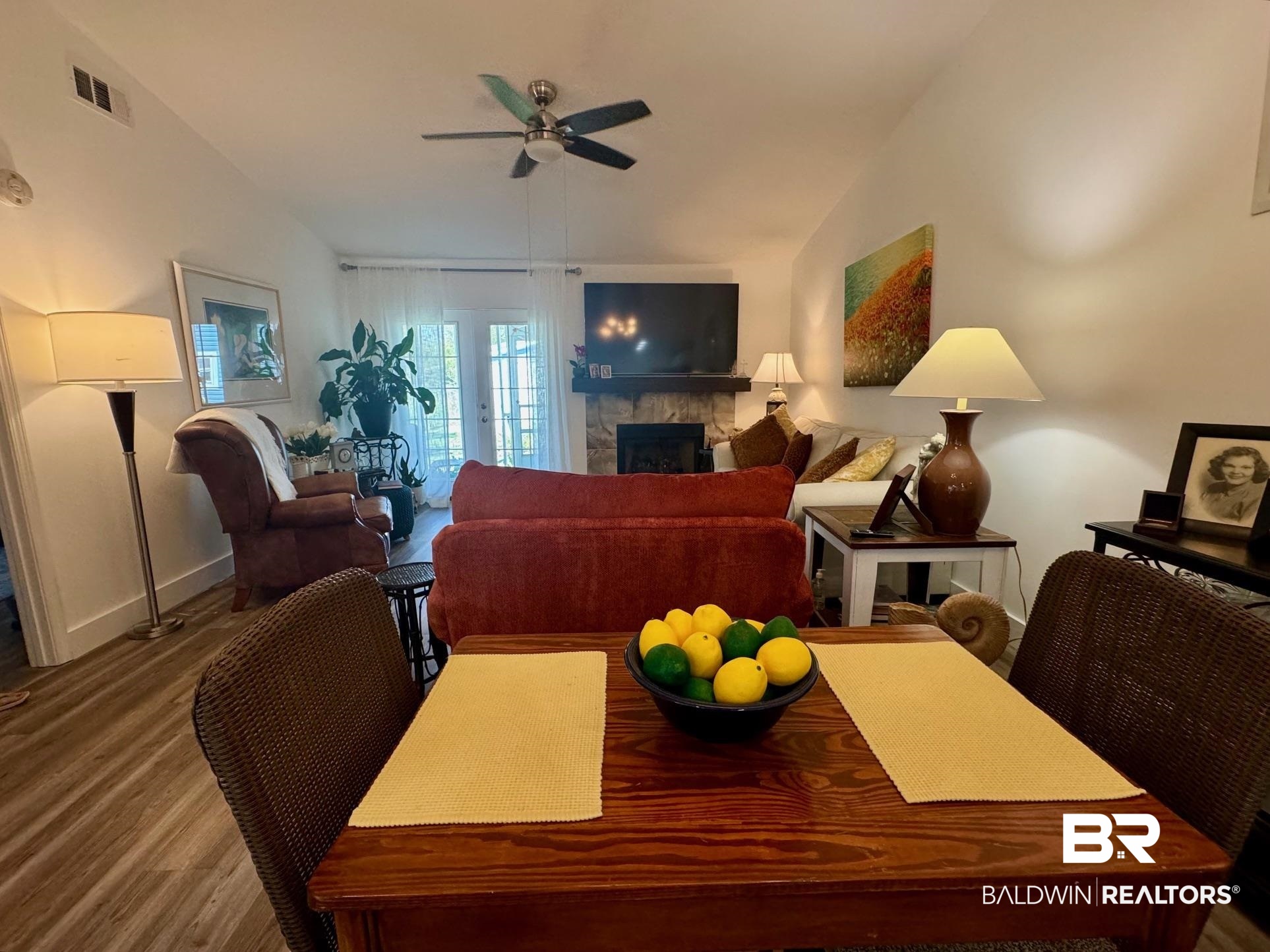 3200 Loop Road, Unit 55 Orange Beach, AL 36561 - Photo 4 of 40 Dining space featuring hardwood / wood-style floors, a fireplace, ceiling fan, and vaulted ceiling