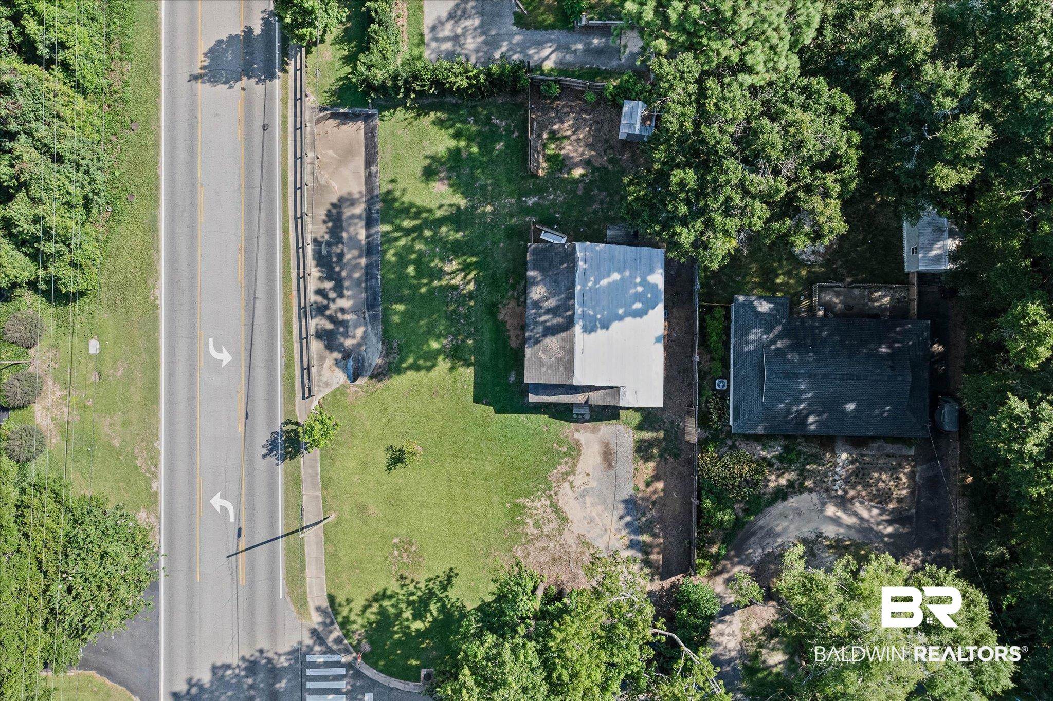 401 Frederick Avenue Fairhope, AL 36532 - Photo 22 of 36 Aerial perspective showcasing a parcel with two structures, extensive surrounding tree cover, and direct road frontage