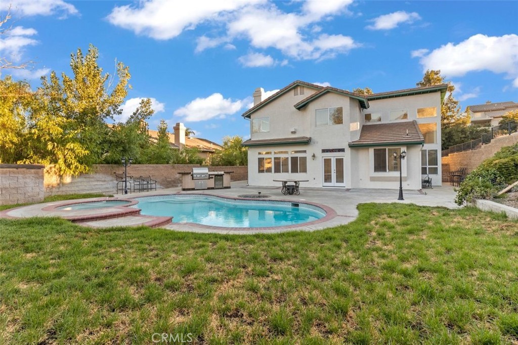 14439 Grandifloras Road Canyon Country, CA 91387 - Photo 43 of 45 a view of a white house with a swimming pool and lawn chairs