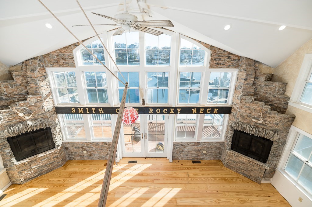 a living room with a fireplace a flat screen tv and a floor to ceiling window