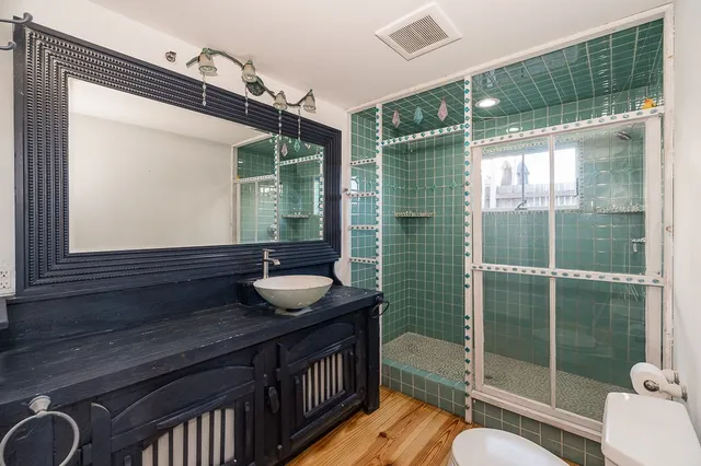 a bathroom with a sink a toilet and shower