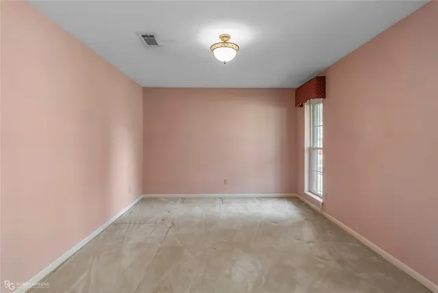 an empty room with windows and ceiling fan