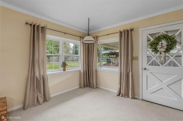 an empty room with a chandelier fan and a window
