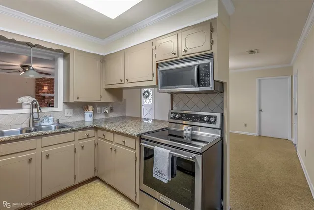 a kitchen with granite countertop cabinets stainless steel appliances and wooden floor