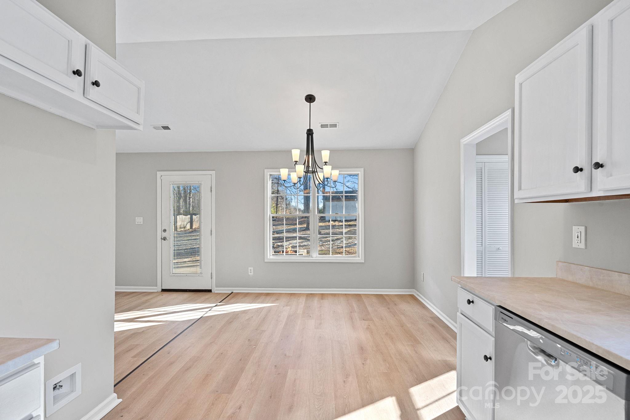 7100 Windsong Way Wingate, NC 28174 - Photo 11 of 26 a view of an empty room with wooden floor and a window