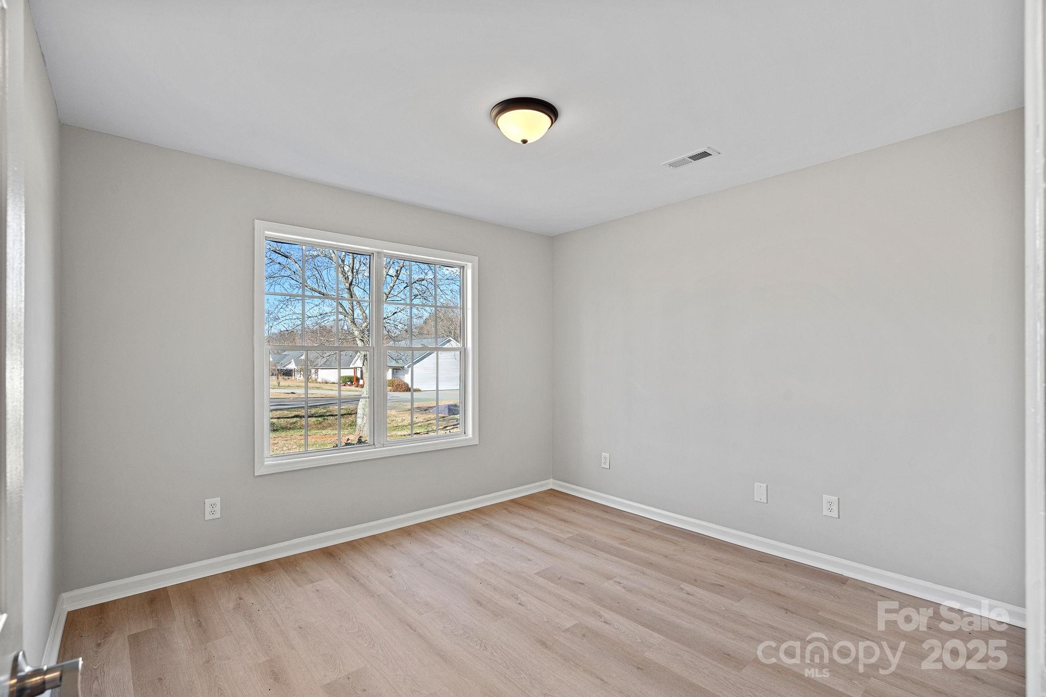 7100 Windsong Way Wingate, NC 28174 - Photo 13 of 26 an empty room with wooden floor and windows