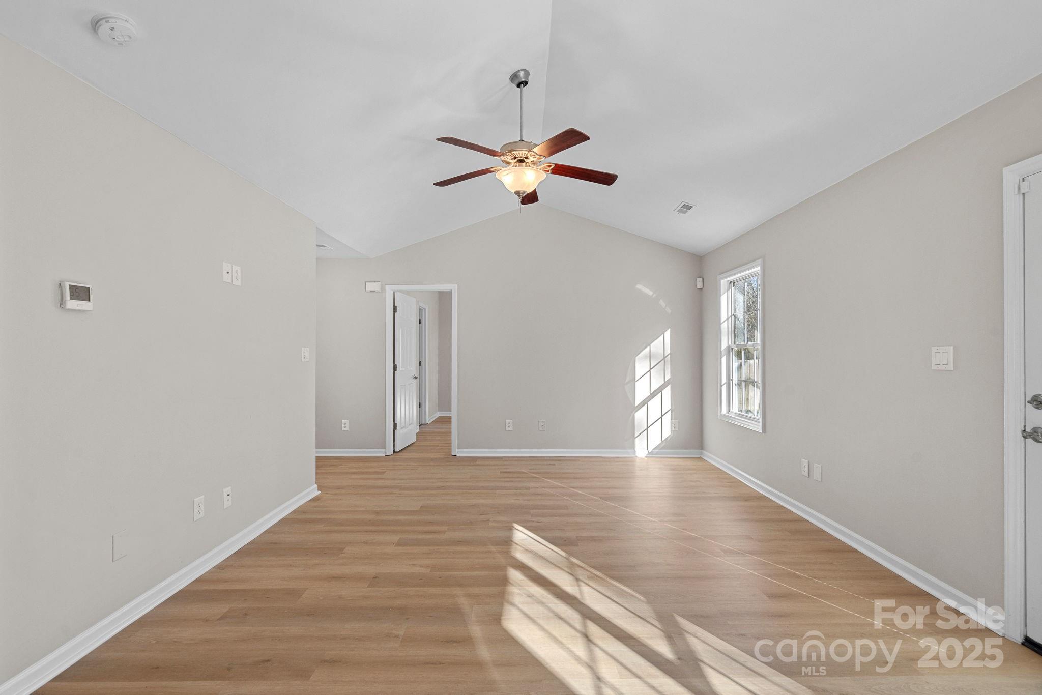 7100 Windsong Way Wingate, NC 28174 - Photo 6 of 26 a view of an empty room with window and wooden floor