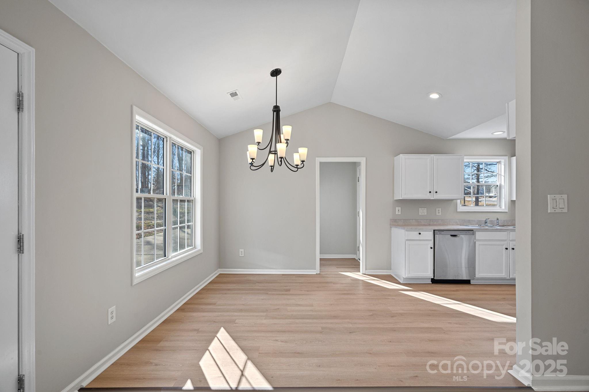 7100 Windsong Way Wingate, NC 28174 - Photo 7 of 26 a view of a kitchen with a sink dishwasher and wooden floor