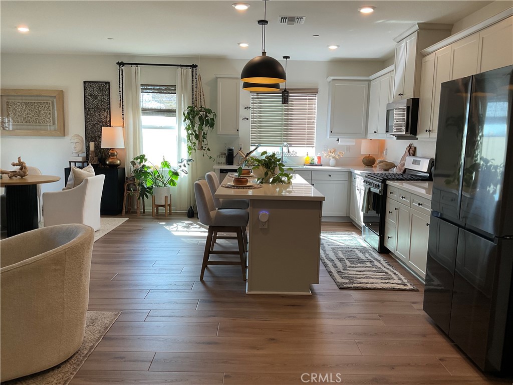 30153 Cyn Rnch Drive Homeland, CA 92548 - Photo 6 of 19 a kitchen with stainless steel appliances granite countertop a refrigerator a stove top oven a dining table and chairs