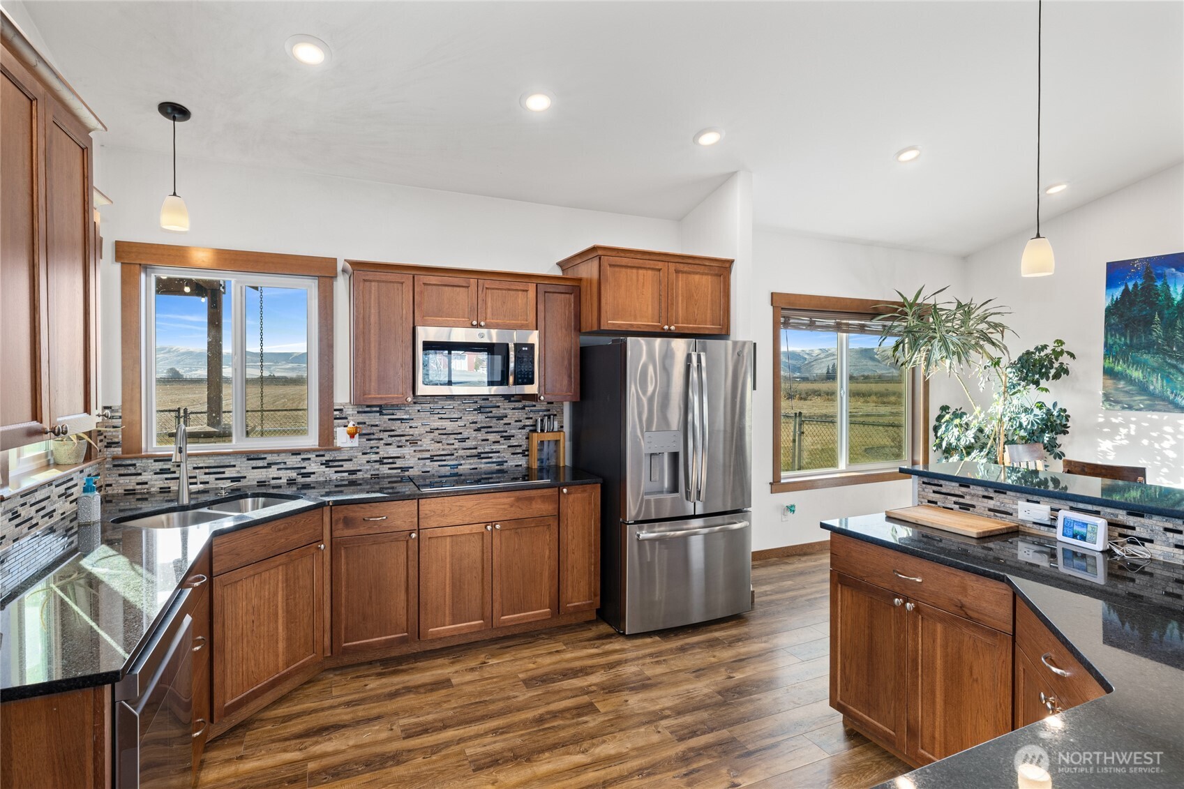 583 Rein Road Ellensburg, WA 98926 - Photo 16 of 40 a kitchen with stainless steel appliances granite countertop a refrigerator a sink dishwasher a stove and a dining table with wooden floor