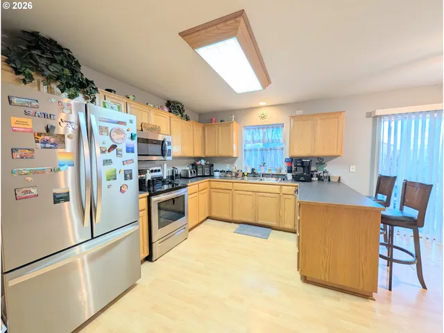 a kitchen with stainless steel appliances a refrigerator sink and cabinets