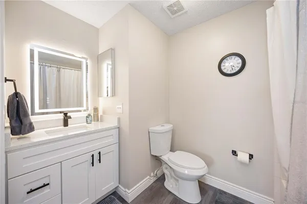a bathroom with a toilet a sink and mirror