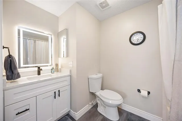 a bathroom with a toilet a sink and mirror