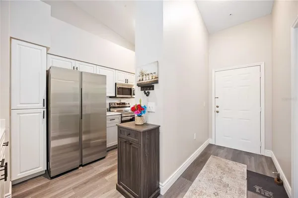 a kitchen with a refrigerator and wooden floor