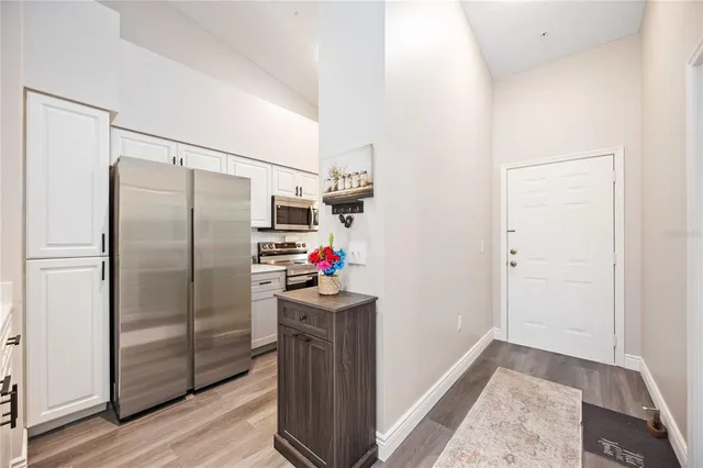a kitchen with a refrigerator and wooden floor
