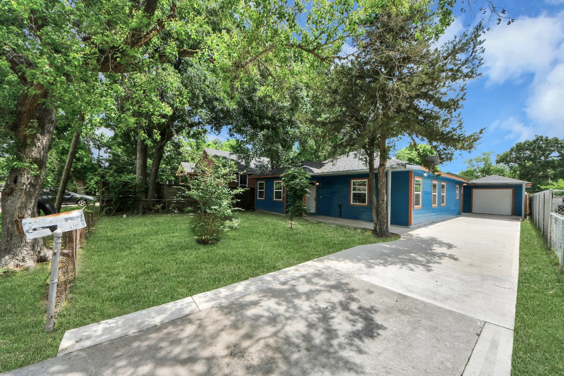 a front view of a house with a garden and trees