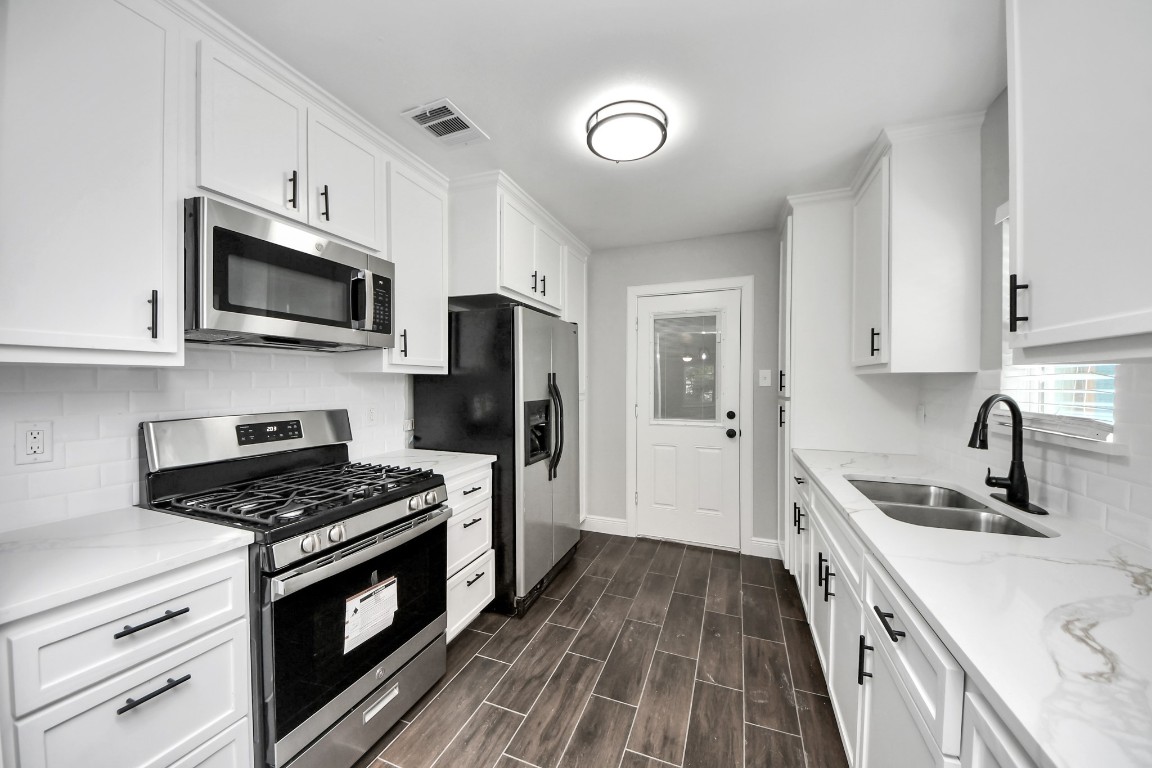 135 Rustic Drive Pasadena, TX 77502 - Photo 16 of 31 a kitchen with sink a microwave a stove and refrigerator