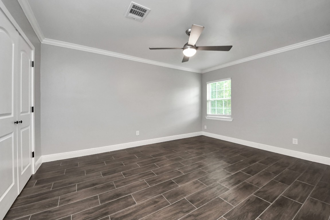 135 Rustic Drive Pasadena, TX 77502 - Photo 22 of 31 an empty room with wooden floor fan and windows