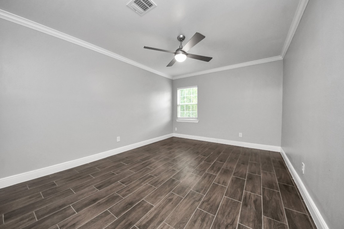 135 Rustic Drive Pasadena, TX 77502 - Photo 23 of 31 an empty room with wooden floor fan and windows