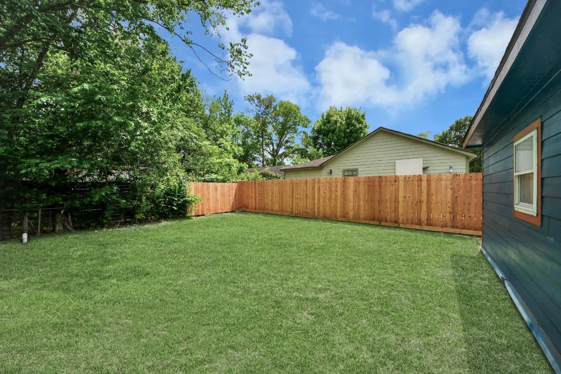 135 Rustic Drive Pasadena, TX 77502 - Photo 5 of 31 a view of a backyard with potted plants and wooden fence