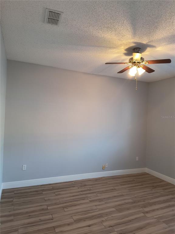 3201 Settlers Trail St. Cloud, FL 34772 - Photo 13 of 38 a view of a room with wooden floor and a chandelier fan