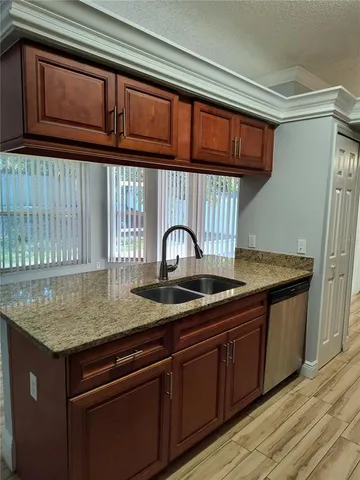 a kitchen with granite countertop wood cabinets and a sink