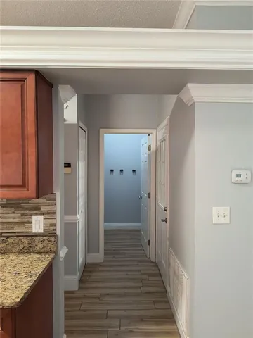 a view of a hallway with wooden floor and staircase