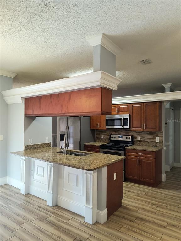 3201 Settlers Trail St. Cloud, FL 34772 - Photo 4 of 38 a kitchen with stainless steel appliances granite countertop a stove a sink and a microwave