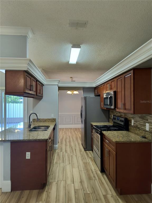 3201 Settlers Trail St. Cloud, FL 34772 - Photo 5 of 38 a kitchen with stainless steel appliances granite countertop a sink stove and cabinets