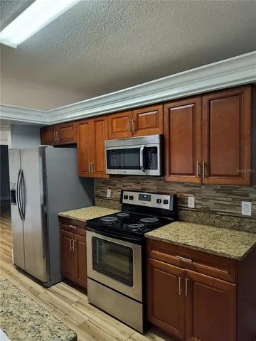a kitchen with stainless steel appliances granite countertop a stove a sink and a microwave