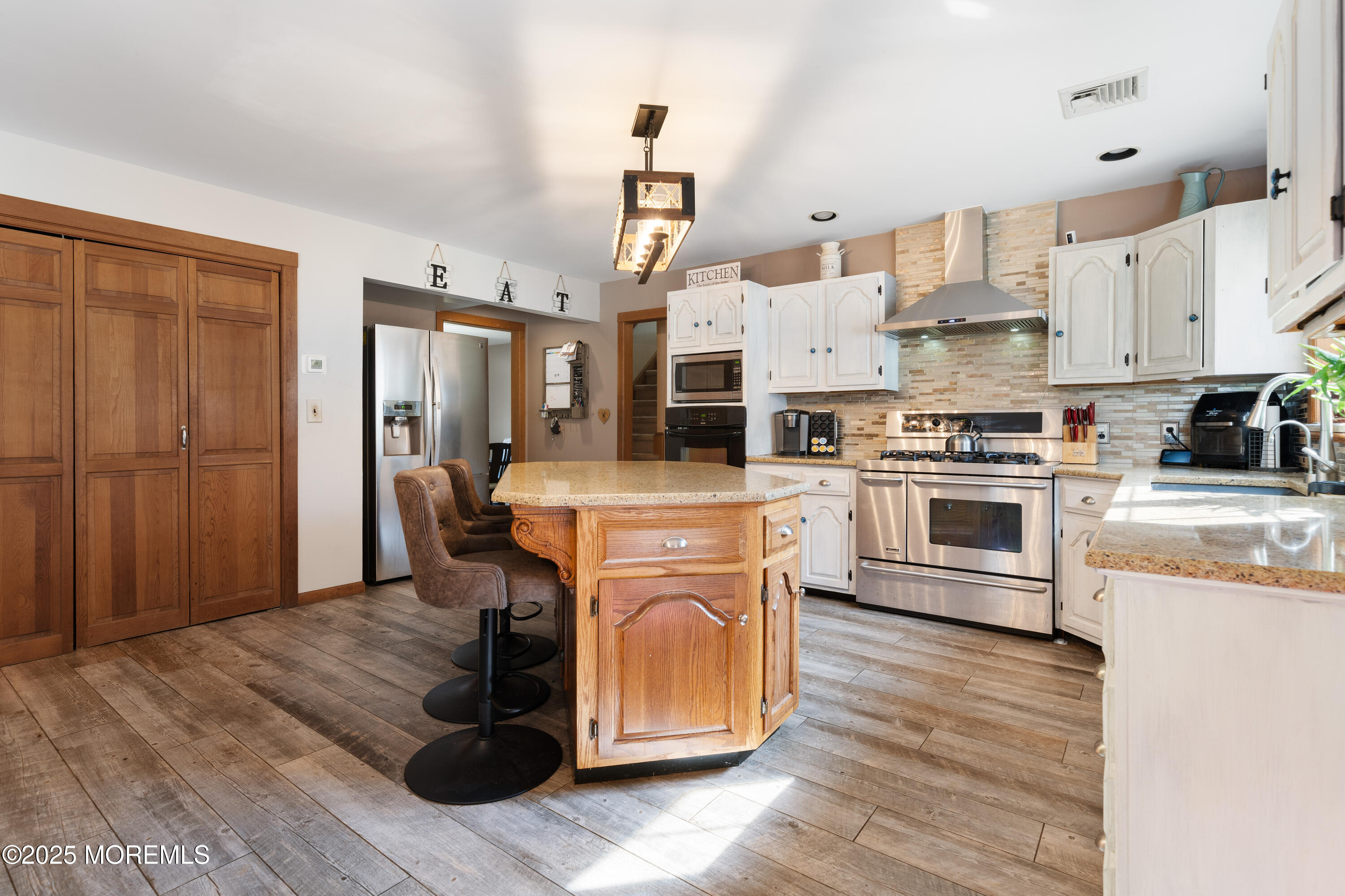 1226 Andover Road Forked River, NJ 08731 - Photo 21 of 44 a kitchen with stainless steel appliances granite countertop a refrigerator a stove top oven a sink dishwasher and white cabinets with wooden floor