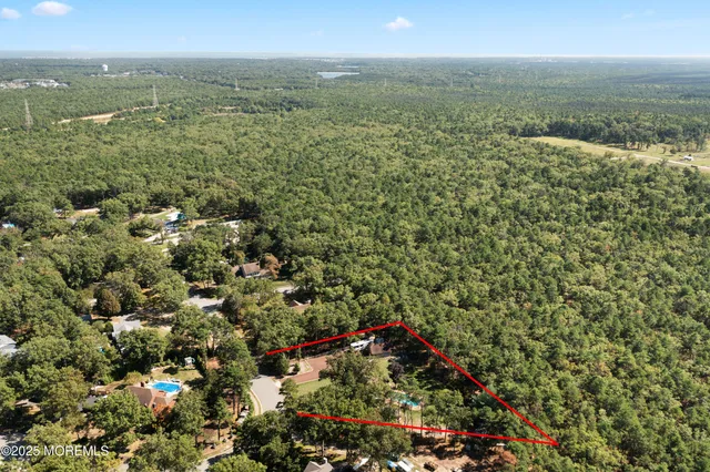 an aerial view of residential houses with outdoor space and trees