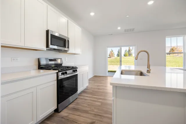 a kitchen with stainless steel appliances granite countertop a sink and a stove top oven