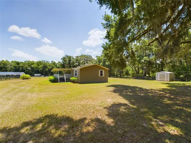 a front view of a house with a yard and lake view