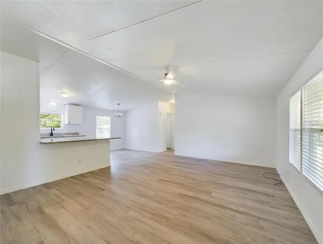 a view of a kitchen with wooden floor and a window